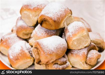 a stack of buns sprinkled with sugar on a white plate
