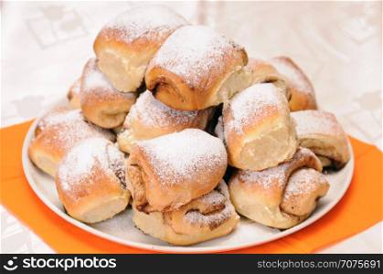 a stack of buns sprinkled with sugar on a white plate