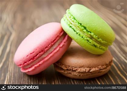 A stack of colorful traditional French dessert makarons on brown wooden background.. French macaroons .Dessert