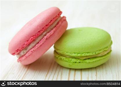 A stack of colorful traditional French dessert makarons on white wooden background.. French macaroons .Dessert