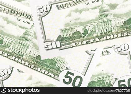 A stack of fifty 50 dollar bills fanned out with the back US Capitol showing on a white background