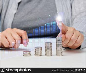a stack of iron coins and a graph with rising indicators. Business growth concept, success. High income