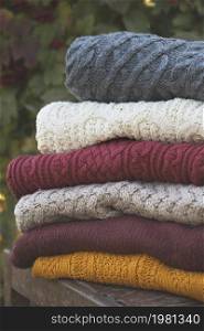 a stack of knitted sweaters on a retro chair in the garden