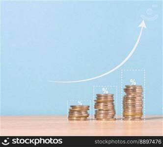 A stack of metallic coins and a graph on a blue background. Income growth in business, high profitability, copy space