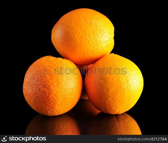 a stack of oranges on black background