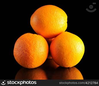 a stack of oranges on black background