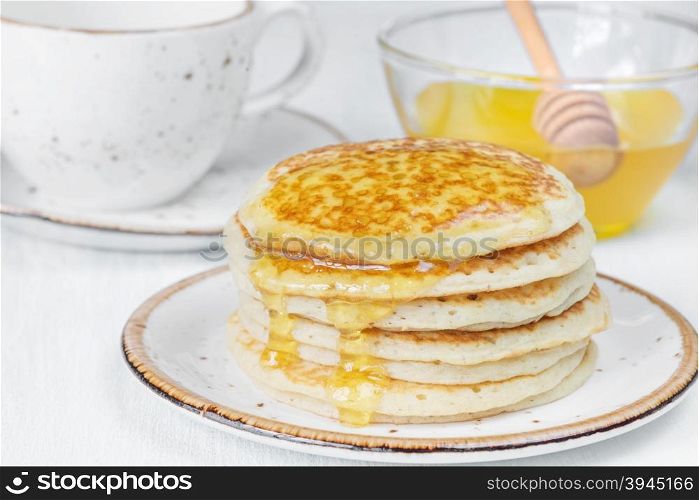 A stack of pancakes drizzled with honey close-up