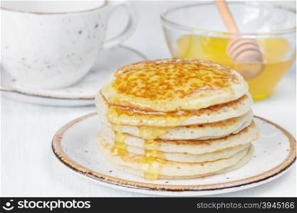 A stack of pancakes drizzled with honey close-up