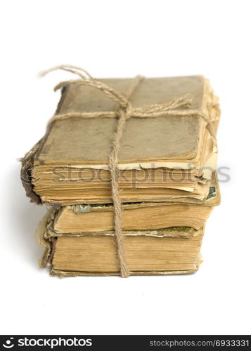 a stack of shabby old books tied with string on white background