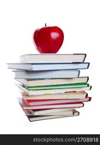 A stack of text books with a big, red apple on top. Shot on white background.