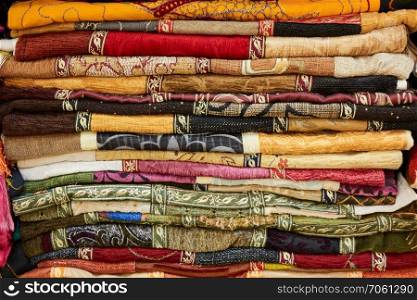 A stack of Turkish colored fabric textile as a background.. Pile of colorful folded textile. Heap of cloth fabric
