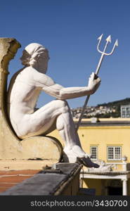 A statue of Neptune holding a trident that is looking over a courtyard on the roof of the Castle of Good Hope in Cape Town, South Africa. Looking closely, a series of cracks are visible throughout sculpture.