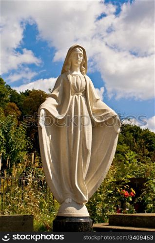 A statue of saint Mary over blue sky