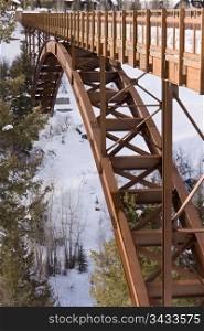 A steel bridge for pedestrians that spans over a deep gorge near Aspen, Colorado. In winter, the bridge is covered with a foot of snow and is used by skiers.