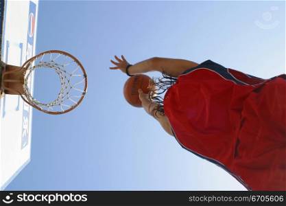 A stock photo of a man shooting a basket ball into the hoop