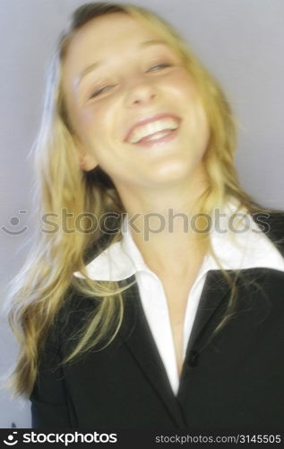 A stock photo of a woman smiline wearing a suit.