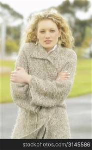 A stock photo of a womn with blonde curley hair in a cold winters day