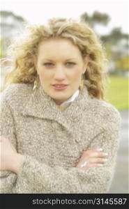 A stock photo of a womn with blonde curley hair in a cold winters day