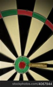 A stock photograph of a dart board with a dart hitting the bulls eye.