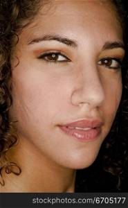 A stock photograph of an attractive young woman with curly hair and dark eyes.
