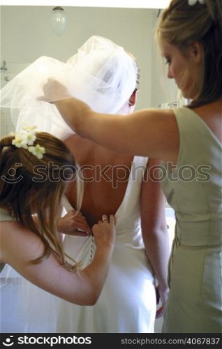 A stock photograph of brides maids prepare a bride for her wedding.