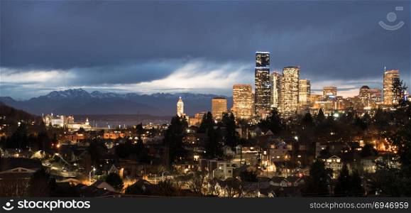 A storm moves over the Olympic Mountains and Puget Sound towards the buildings and architecture of Seattle Washington
