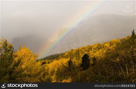 A storm passes over the east entrance of Glacier National Park creating a rainbow
