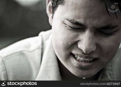 A stressed and depressed young asian male in black and white