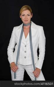 A studio shot of an attractive caucasian woman in her thirties wearing a white suit in front of a black background