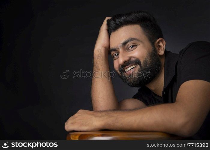 A STYLISH BEARDED MAN POSING IN FRONT OF CAMERA
