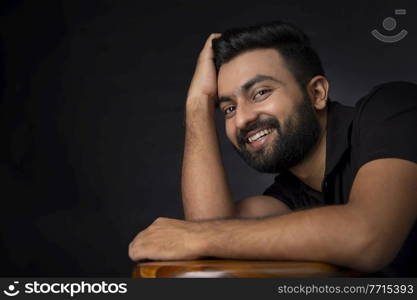 A STYLISH BEARDED MAN POSING IN FRONT OF CAMERA