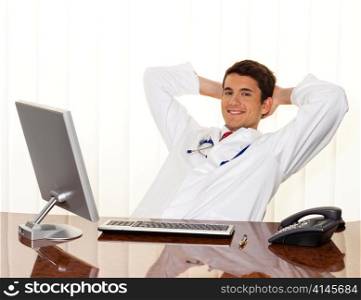 a successful young doctor sitting at desk, smiling.