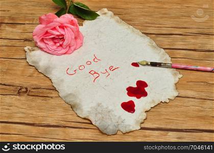A suicide note on an old paper covered in blood with a vintage fountain pen and a pink rose