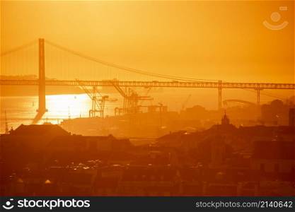 a sunset from the castelo with the Ponte 25 de Abril or 25the April Bridge at the Rio Tejo near the City of Lisbon in Portugal. Portugal, Lisbon, October, 2021