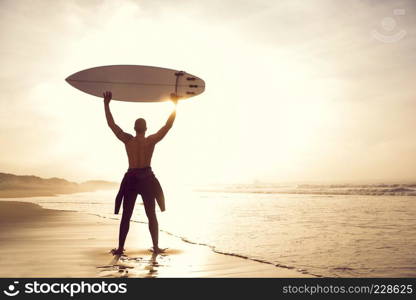 A surfer with his surfboard at the beach