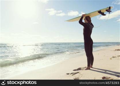 A surfer with his surfboard at the beach