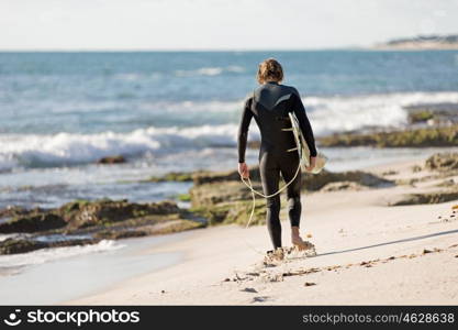 A surfer with his surfboard at the beach