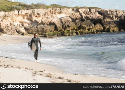 A surfer with his surfboard at the beach