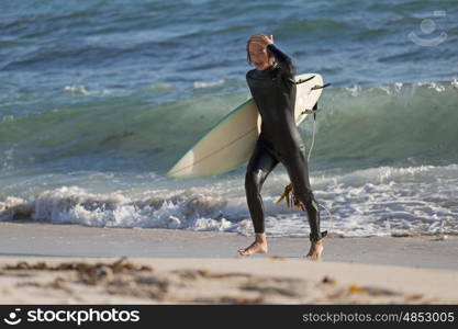 A surfer with his surfboard at the beach