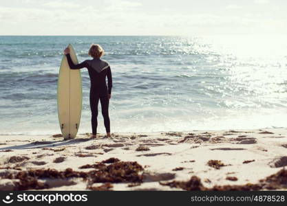 A surfer with his surfboard at the beach