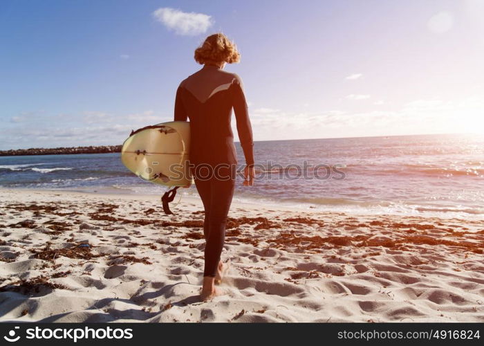 A surfer with his surfboard at the beach