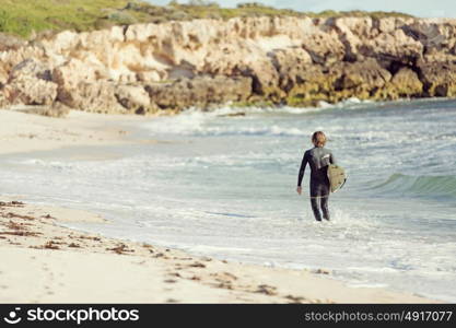 A surfer with his surfboard at the beach