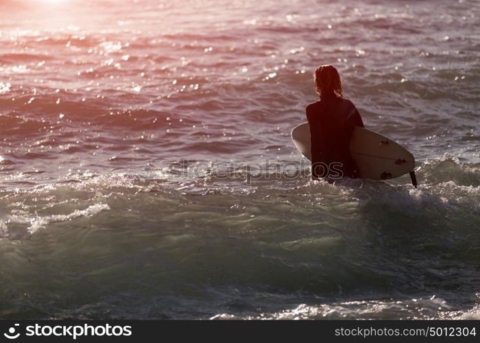 A surfer with his surfboard at the beach