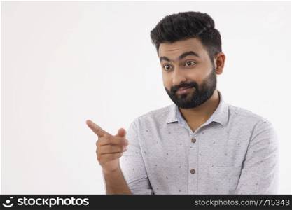 A SURPRISED BEARDED MAN POINTING HIS FINGER AWAY