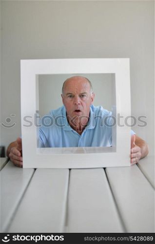 A surprised elderly man framed by a square