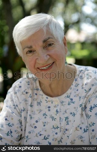 A sweet elderly grandmother outside.