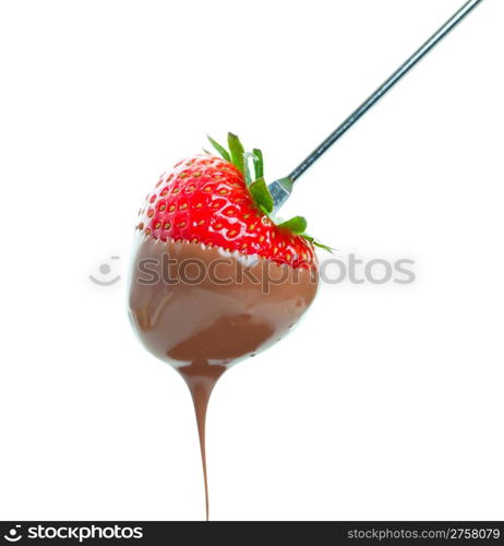 A sweet ripe strawberry dripping with warm milk chocolate. Shot on white background.