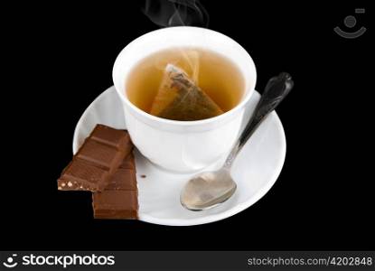 a sweets chocolate with cup of the tea on black