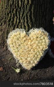 A sympathy flower arrangement in a heart shape, white roses