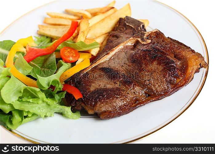 A T-bone steak, pan-seared and served with salad and fries.